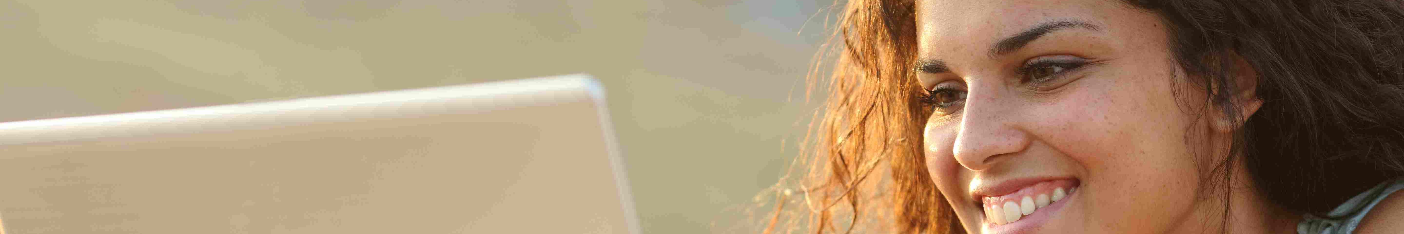 © lizenziert by Ingram Images Lächelnde Frau entspannt am Laptop.