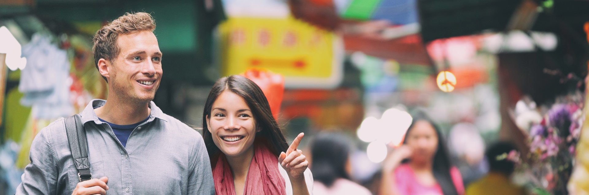 Eine Frau und ein Mann spazieren vor einem verschwommenen Hintergrund