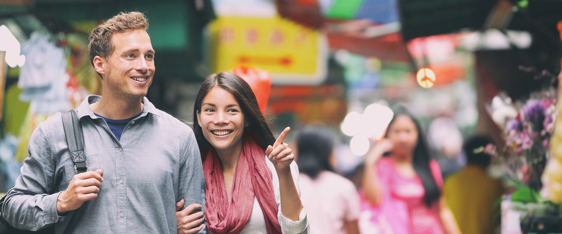 Eine Frau und ein Mann spazieren vor einem verschwommenen Hintergrund